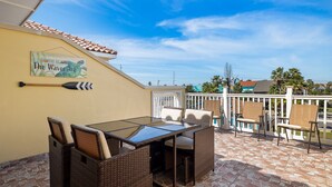 Une terrasse avec une table et des chaises, une fresque murale et un sol carrelé.