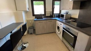 A compact kitchen with a washing machine, microwave, and a sink. - Les Marronniers, Six-Fours-les-Plages / 10 min from the beach, 4-room, 78 m² (Six-Fours-les-Plages)