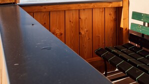 A wooden cabin with a large window overlooking a snowy mountain. - Quaint, rustic vacation home with hut flair on the sunny side of the Grimming (Mitterberg-St.Martin)