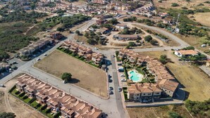 An aerial view of a residential area with multiple buildings, roads, and a swimming pool.