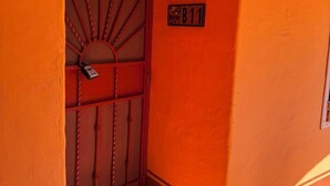 A hallway with a red door and a sign indicating room number B11. - Brisa del Mar – Pool, Near Mirador Beach (Puerto Penasco)