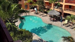 A resort with a swimming pool surrounded by palm trees and lounge chairs. - Brisa del Mar – Pool, Near Mirador Beach (Puerto Penasco)