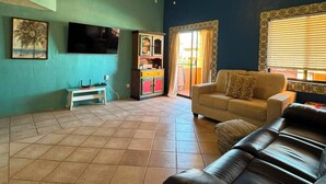 A living room with a ceiling fan, a television, a sofa, and a cabinet. - Brisa del Mar – Pool, Near Mirador Beach (Puerto Penasco)