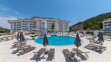 Una piscina al aire libre de temporada, sombrillas