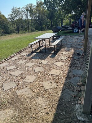 An outdoor patio area with picnic tables and a gravel path.
