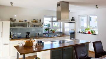 A modern kitchen with white cabinets, a wooden countertop, and a built-in oven.