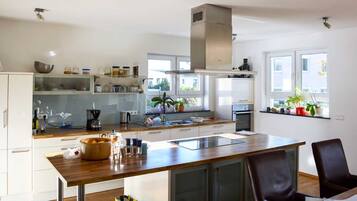 Eine moderne Küche mit weißen Schränken, einer Holz Arbeitsplatte und einem eingebauten Backofen.
