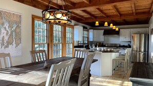 A spacious kitchen with wooden beams, a large island, and modern appliances. - Spacious Getaway with Sauna, Close to Newport & Beaches (Middletown)
