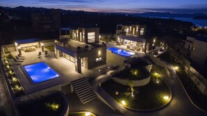 A modern villa with two swimming pools, a covered patio, and a landscaped garden. - Brand New Luxury villa★Sauna & Jacuzzi★Walk to Everything★Private Heated Pool (Galatas)