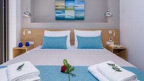 A modern hotel room with a large bed, two bedside tables, a wall-mounted artwork, and a view of the sea. - Brand New Luxury villa★Sauna & Jacuzzi★Walk to Everything★Private Heated Pool (Galatas)