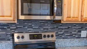 A kitchen with a stainless steel microwave, oven, and stovetop.