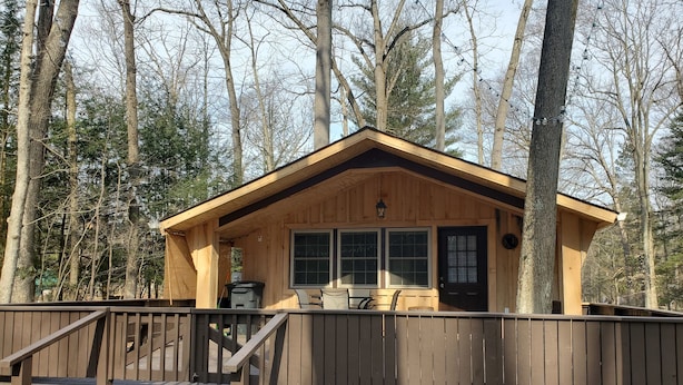 Eine Holzdiele mit Veranda, einem kleinen Tisch und einem Stuhl.