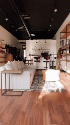 Ein modernes Interieur mit einer Couch, einem Hocker und Barhocker.