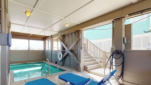 A pool area with a staircase leading to an upper deck, lounge chairs, and a lifebuoy. - Fort Sun, West. Gorgeous 7BR Beachfront. Extra fridges. Private Pool! Sleeps 24. (Gulf Shores)