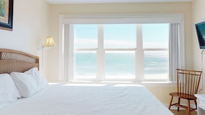 A bedroom with a large bed, a chair, a lamp, and a view of the ocean. - Fort Sun, West. Gorgeous 7BR Beachfront. Extra fridges. Private Pool! Sleeps 24. (Gulf Shores)