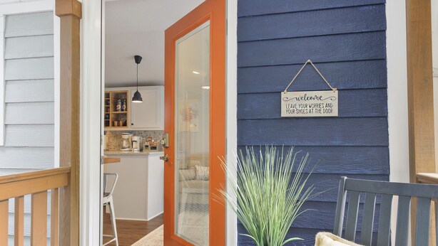 A wooden deck with a blue mat, a bench, and a potted plant. - The Funky Fuji @Backyard Apple Cottages (Flat Rock)