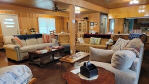 Ein gemütliches Wohnzimmer mit Holzwänden und -decke, zwei Sofas, einem Couchtisch und einem Kamin.