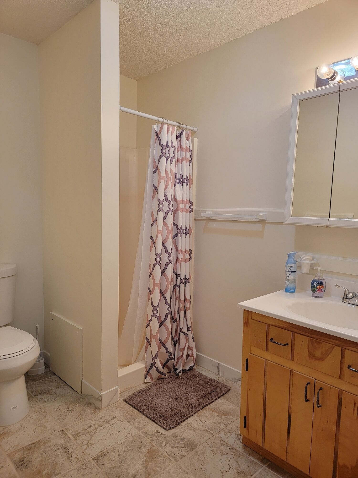 Ein Badezimmer mit Toilette, Duschvorhang, Waschbecken und Holzausstattung.