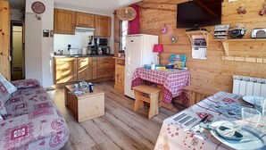 Interior acogedor de una cabaña con cocina, comedor y sofá.
