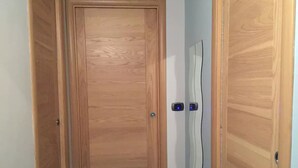 A wooden door with a handle and a lock, flanked by two wooden panels. - CASA CONCETTA (Napoli)