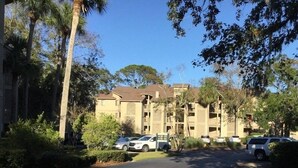 A multi-story residential building with a parking area in front. - 2BR Resort condo with free rounds of Golf & Tennis , beach access pool view (Hilton Head Island)