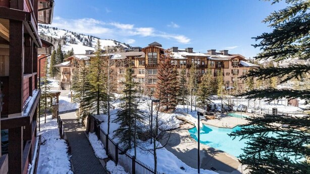 Un resort con varias edificaciones, una piscina y paisajes nevados.