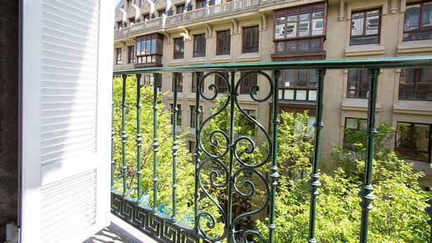 A balcony with ornate iron railings overlooking a building with multiple windows and balconies. - Select, Downtown, next to Avda., 5 min. walk to beaches and Old Town (Donostia)