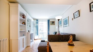 A dining area with a wooden table and chairs, a sofa, and a radiator. - Select, Downtown, next to Avda., 5 min. walk to beaches and Old Town (Donostia)