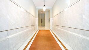 A hallway with marble walls, a brown carpet, and a light fixture. - Select, Downtown, next to Avda., 5 min. walk to beaches and Old Town (Donostia)
