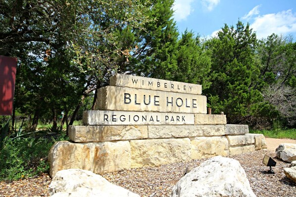 Une plaque en pierre portant l’inscription : « Parc régional de Wimberley Blue Hole ».