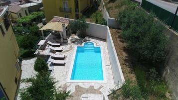 pool surrounded by a deck and lush garden, perfect for relaxation.