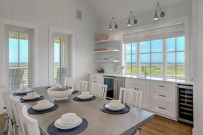 Enjoy meals with family and friends in this spacious dining area with a large table and shelves.