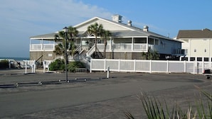 Et hotel ved stranden med en toetagers bygning, en balkon og en trappe til øverste etage.