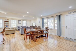 Cozy living area with a dining table, sofa, and bookshelf, perfect for relaxing and socializing.