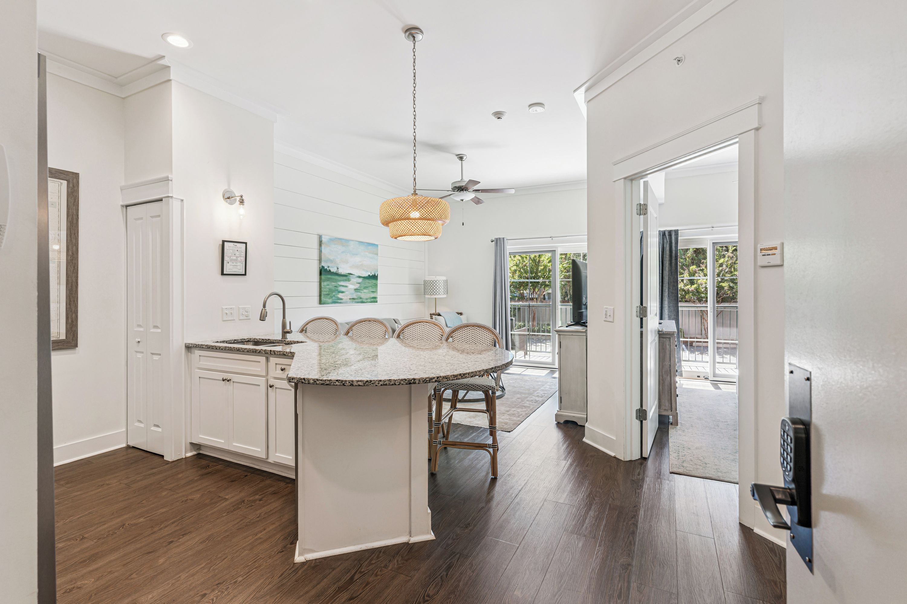 Step into your bright, open kitchen and dining space with coastal charm—beautiful hardwood floors, elegant countertops, and doors opening to your private outdoor area. Perfect for cooking, gathering, and enjoying relaxed vacation moments.