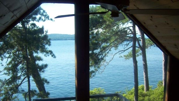 Eine Hütte mit Blick auf einen See und Bäume.