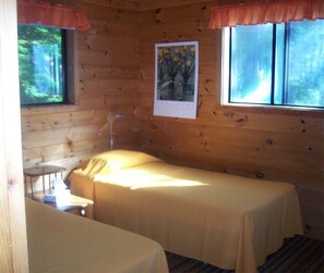 Cozy cabin with a bed, bedside table, and window.