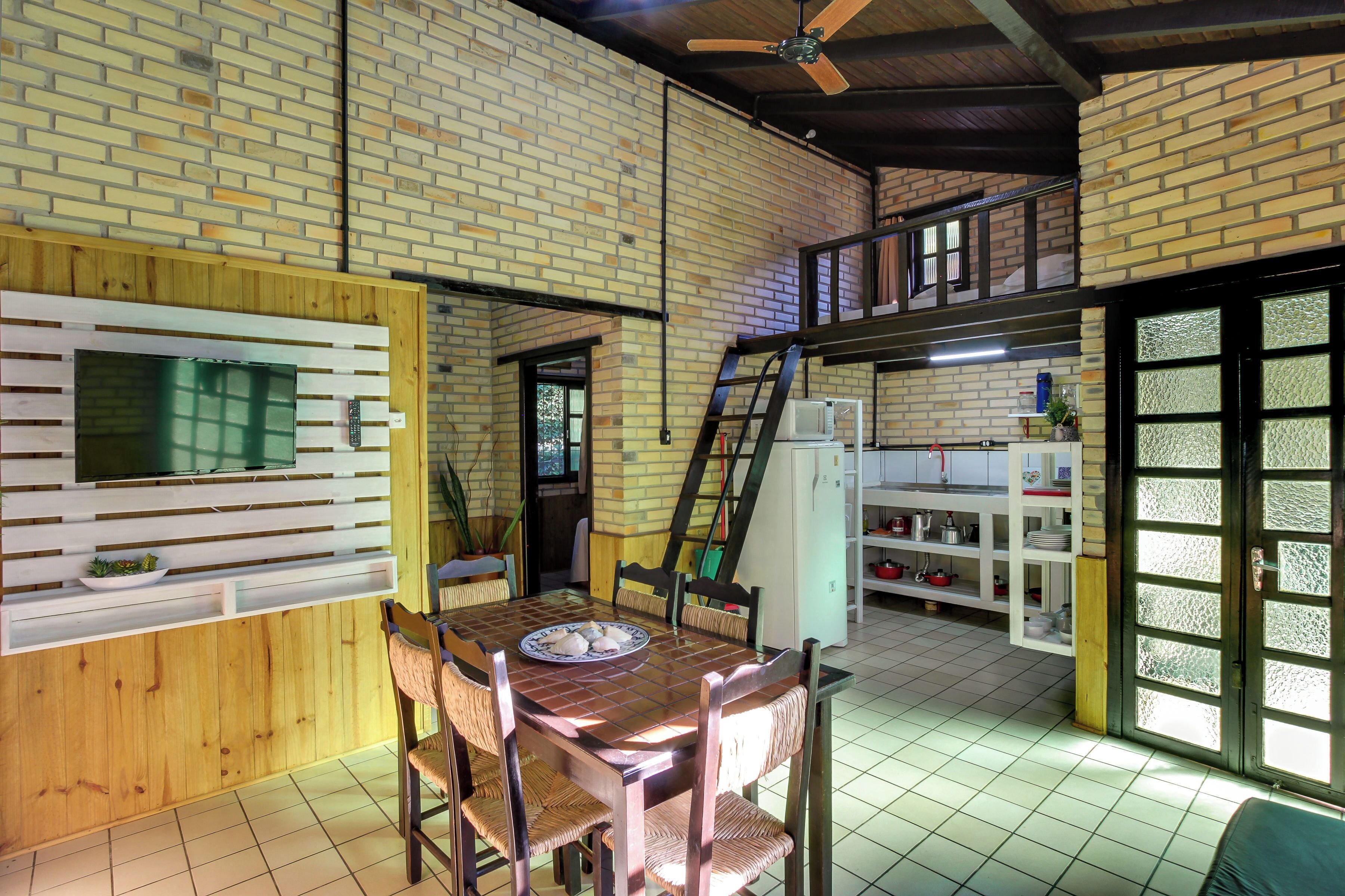 Un comedor con pared de ladrillo, paneles de madera y un ventilador de techo.