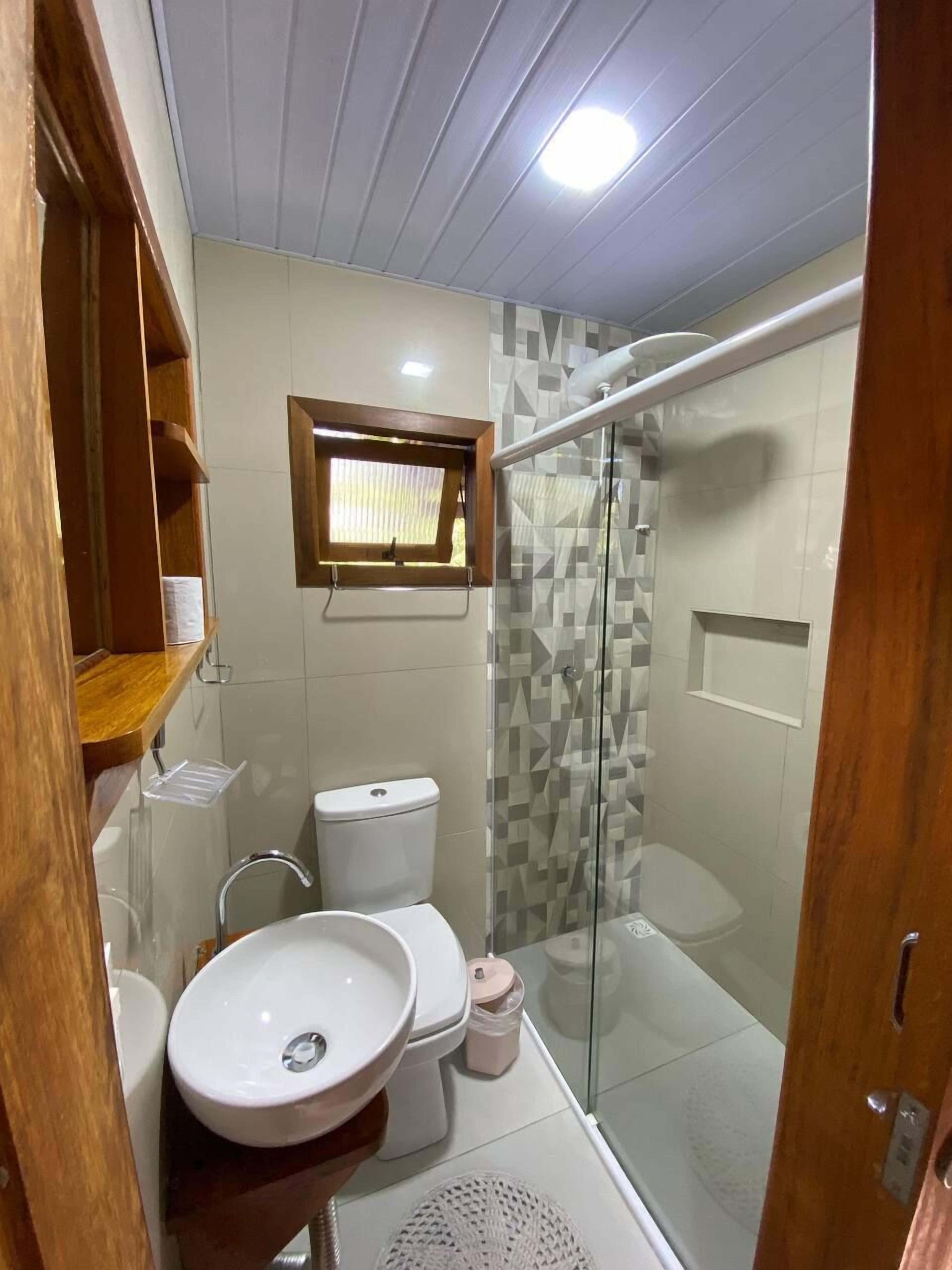 Une salle de bain équipée de toilettes, d’un lavabo et d’une douche.