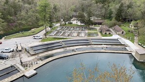 A large water body with a dock, surrounded by a parking area and buildings.