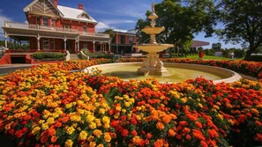 A historic building with a fountain surrounded by vibrant flower beds. - Wattle Avenue House Bed & Breakfast (Mildura)
