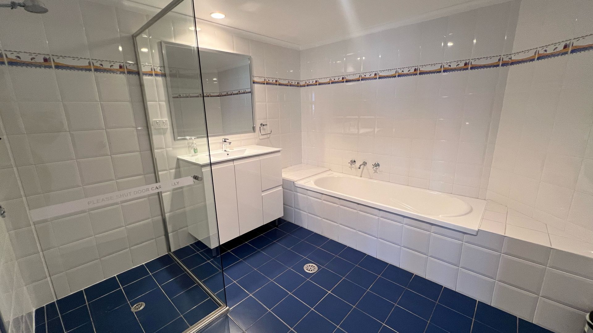 A bathroom with a bathtub, a sink, and a shower area.