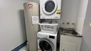 Ein Waschraum mit einer Waschmaschine, einem Trockner und einem Waschbecken.