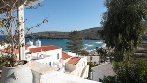 A coastal town with white buildings, red-tiled roofs, and a view of the sea. - Summer Sunrice Andros (Andros)
