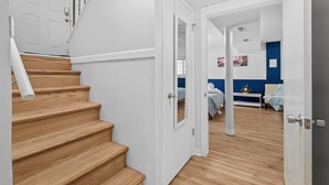 Escadaria que leva a um quarto com cama, mesa de cabeceira e criado-mudo.