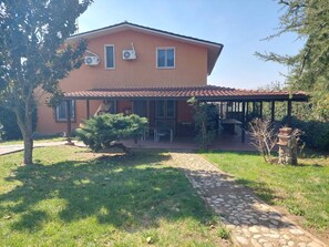 Una casa de dos pisos con un porche cubierto, un sendero de piedra y un pequeño jardín.