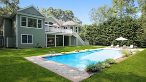 A two-story house with a backyard swimming pool, a covered patio, and a staircase leading to a balcony. - Bridgehampton gem in private community- 1 mile from the village (Bridgehampton)