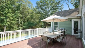 A covered patio with a table and chairs, a grill, and a pool. - Bridgehampton gem in private community- 1 mile from the village (Bridgehampton)
