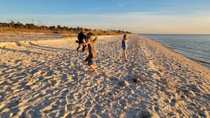 Une plage de sable avec des empreintes et un ciel dégagé.