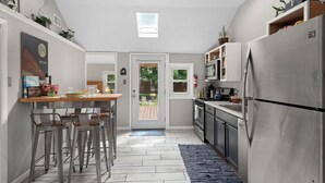 A compact kitchen with a central island, stainless steel appliances, and a view to the backyard. - Music Lover’s Getaway - Red Rocks + Denver (Wheat Ridge)